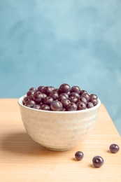 Bowl with fresh acai berries on table