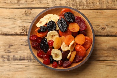 Photo of Mix of delicious dried fruits on wooden table, top view