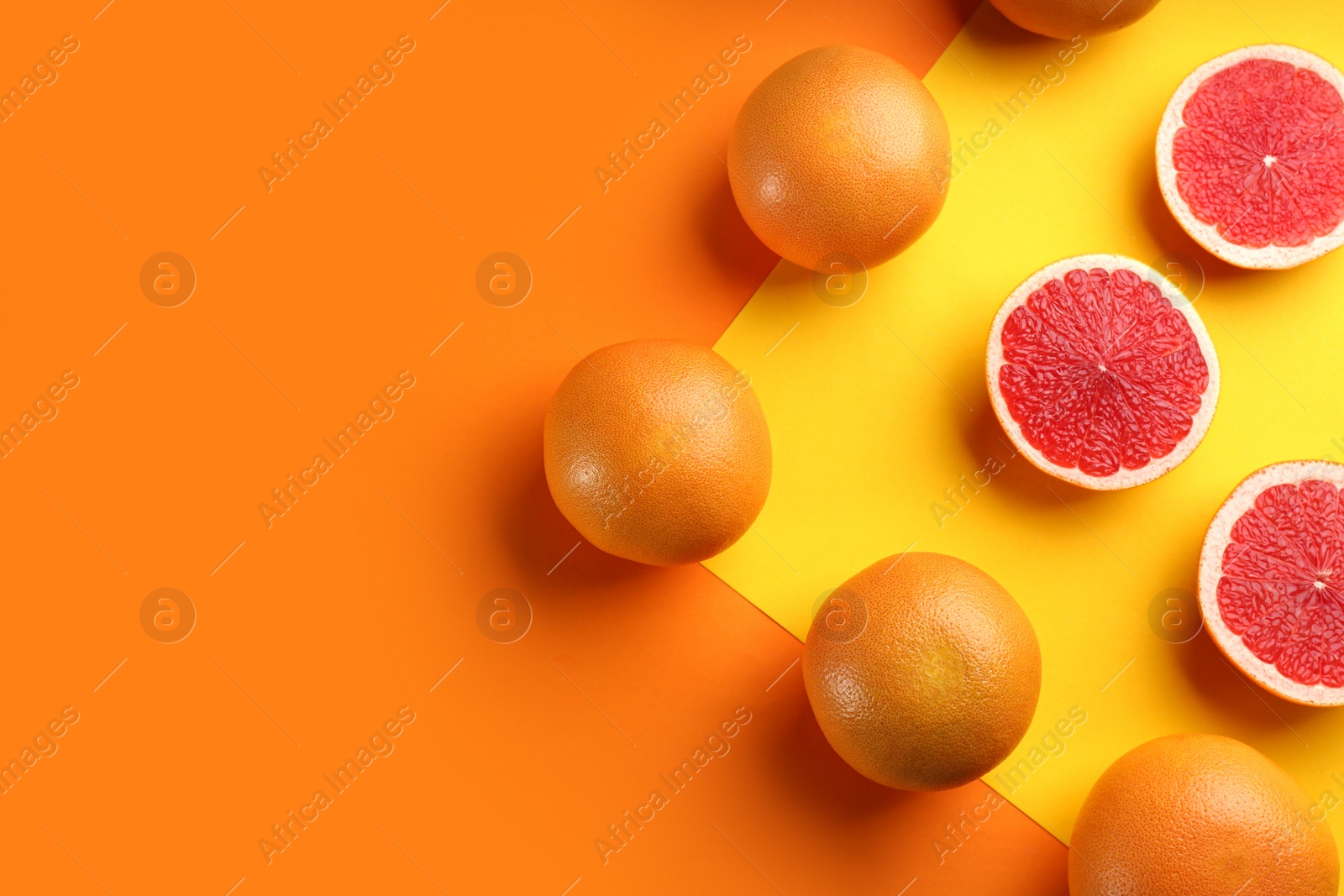 Photo of Cut and whole ripe grapefruits on color background, flat lay