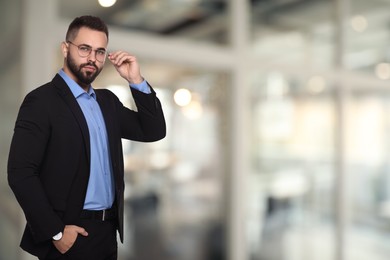 Successful lawyer in glasses on blurred background, space for text