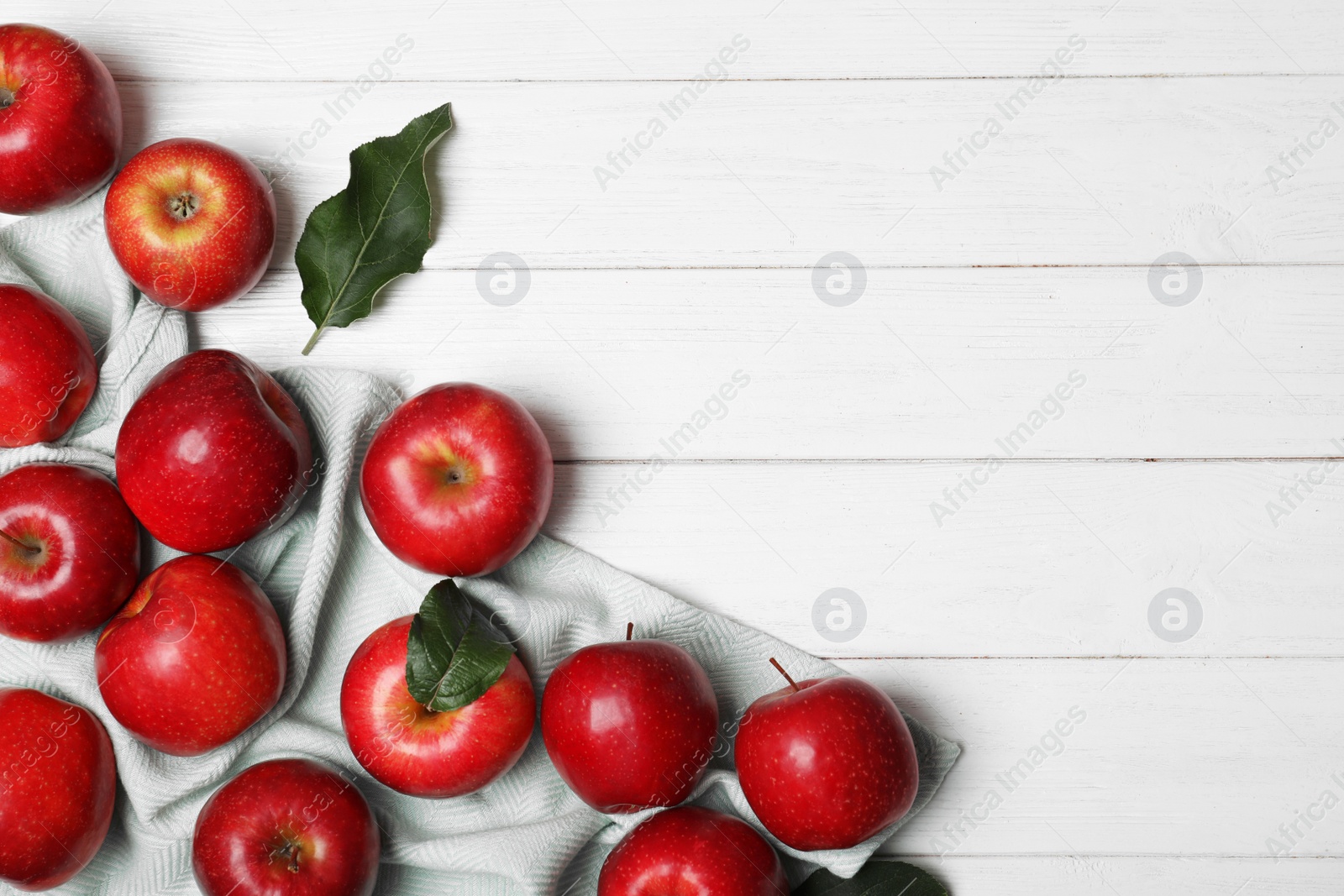 Photo of Many juicy red apples and space for text on wooden background, top view
