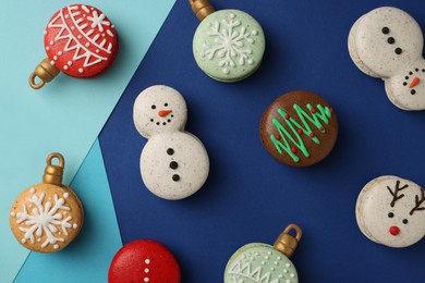 Beautifully decorated Christmas macarons on color background, flat lay