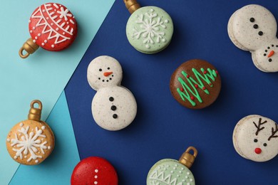 Photo of Beautifully decorated Christmas macarons on color background, flat lay