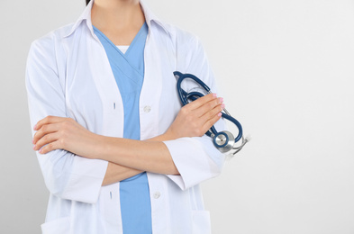 Young doctor with stethoscope on white background, closeup