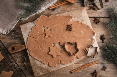 Photo of Making Christmas cookies. Flat lay composition with raw dough and cutters on wooden table