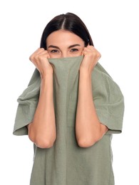 Embarrassed young woman covering face with shirt on white background