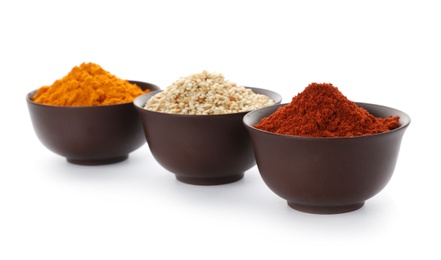 Different aromatic spices in bowls on white background