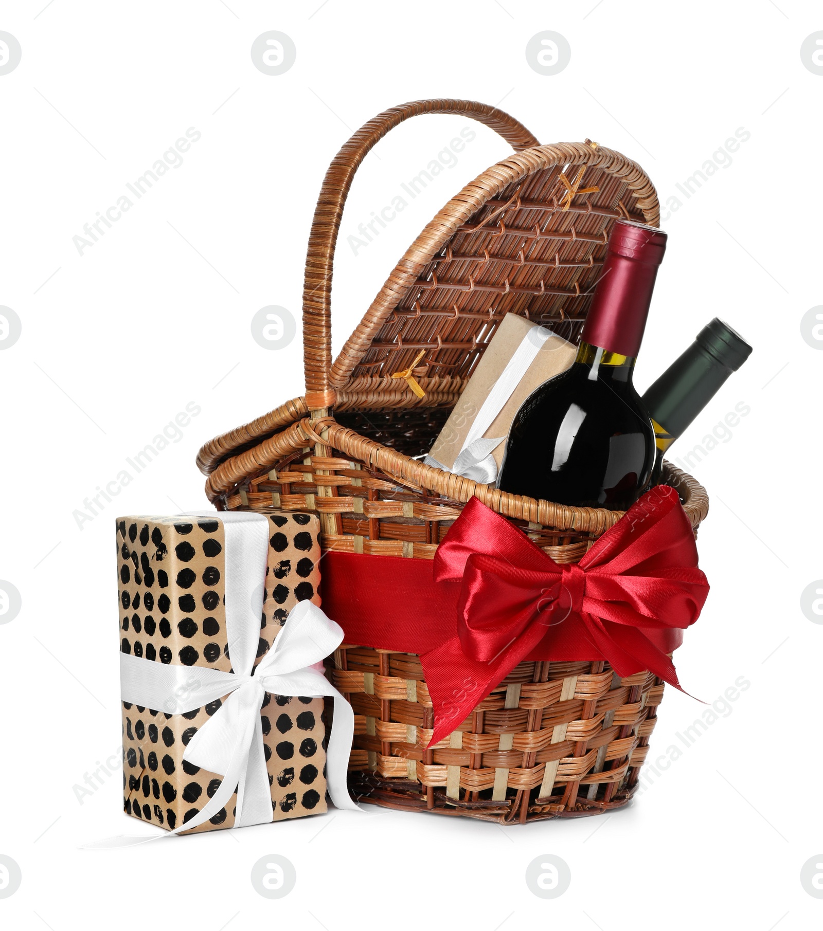 Photo of Festive basket with bottles of wine and gifts on white background