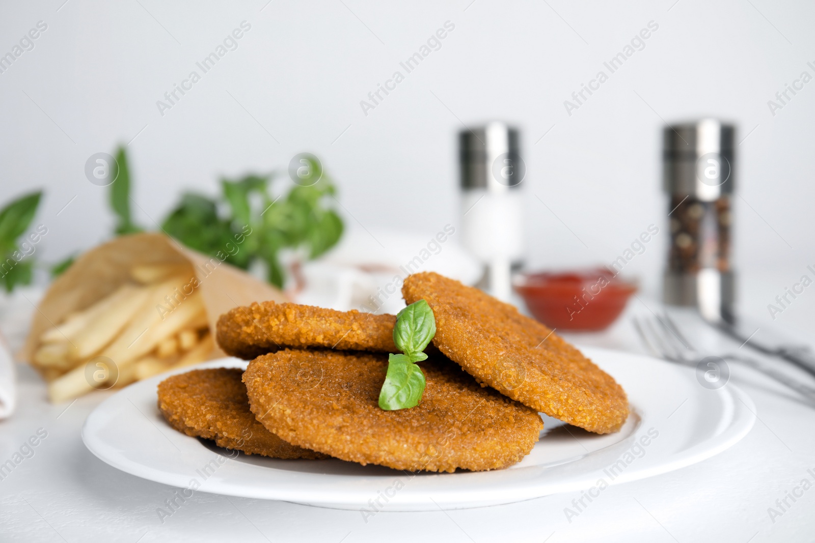 Photo of Delicious fried breaded cutlets served on white table, closeup