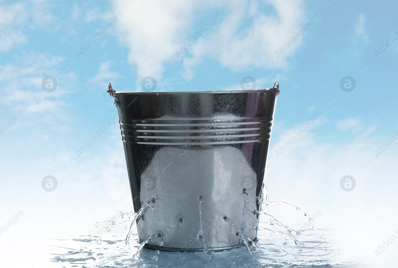 Image of Leaky bucket with water against blue sky 
