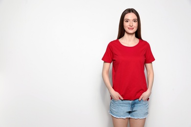 Young woman in t-shirt on light background. Mock up for design