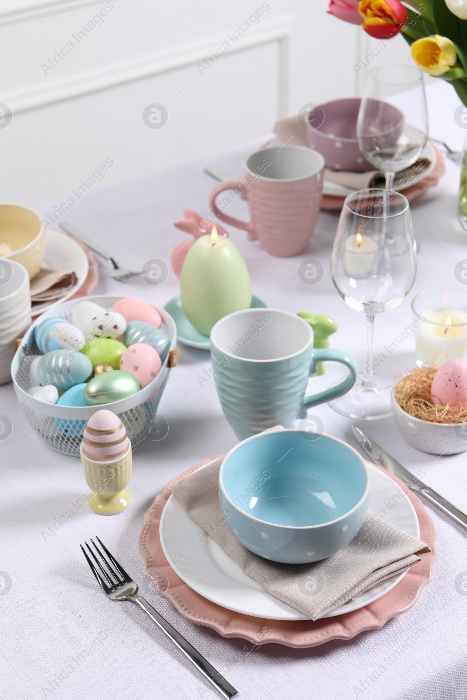 Photo of Festive table setting with painted eggs. Easter celebration