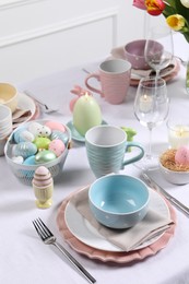 Photo of Festive table setting with painted eggs. Easter celebration