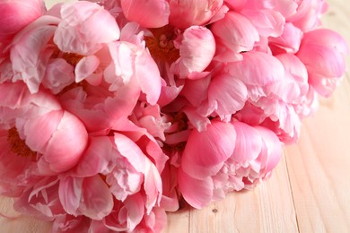 Photo of Beautiful pink peonies on wooden table, closeup