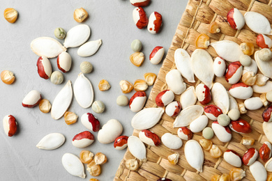 Mixed vegetable seeds on grey background, flat lay