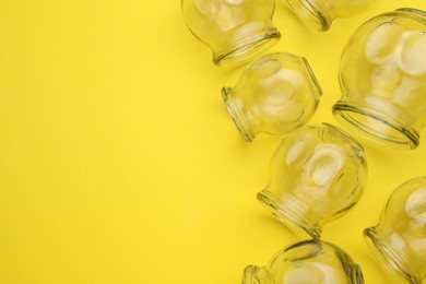 Photo of Glass cups on yellow background, flat lay and space for text. Cupping therapy