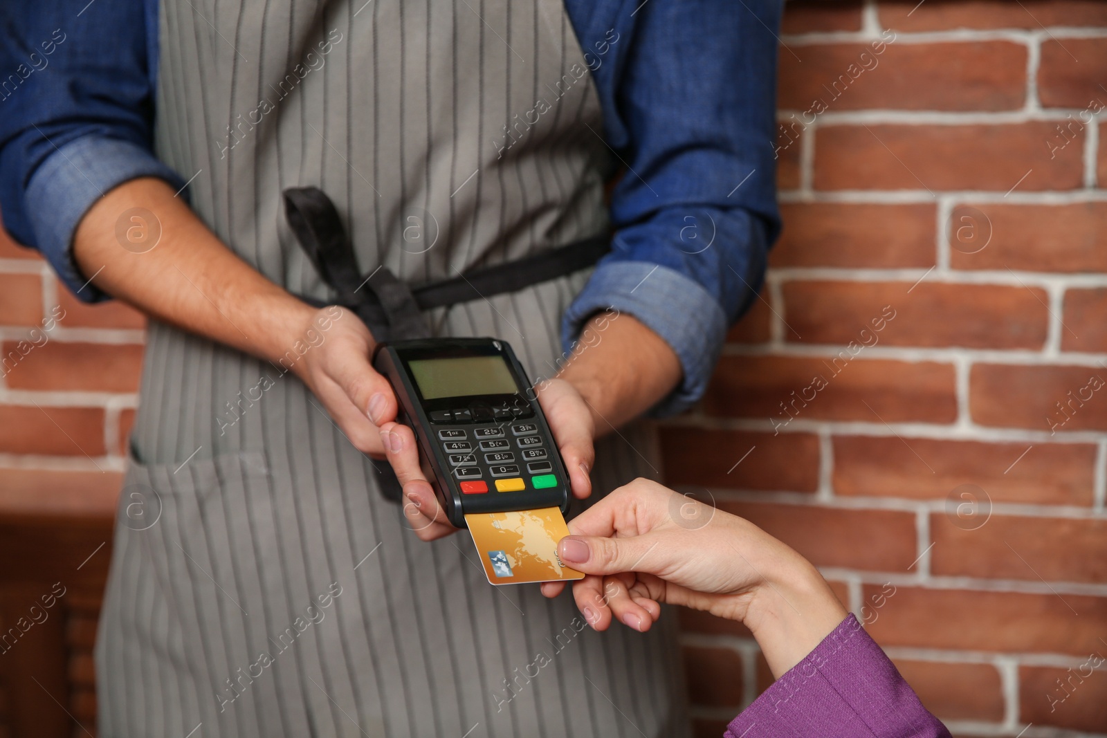 Photo of Woman using terminal for credit card payment in cafe, closeup