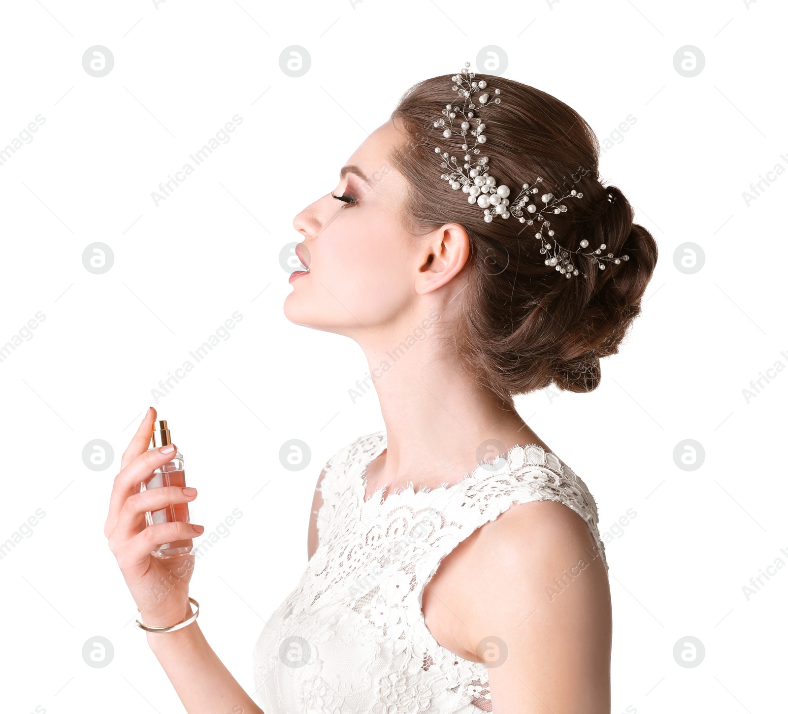 Photo of Beautiful young bride with bottle of perfume on white background