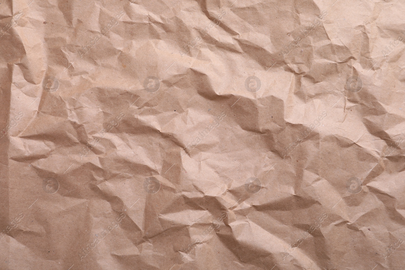 Photo of Texture of wrinkled kraft paper bag as background, closeup