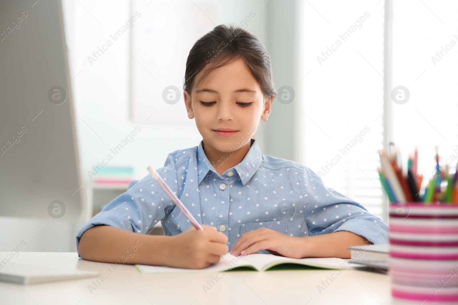 Photo of Distance learning, studying at home. Girl having online school lesson during quarantine and lockdown due to Covid-19 pandemic