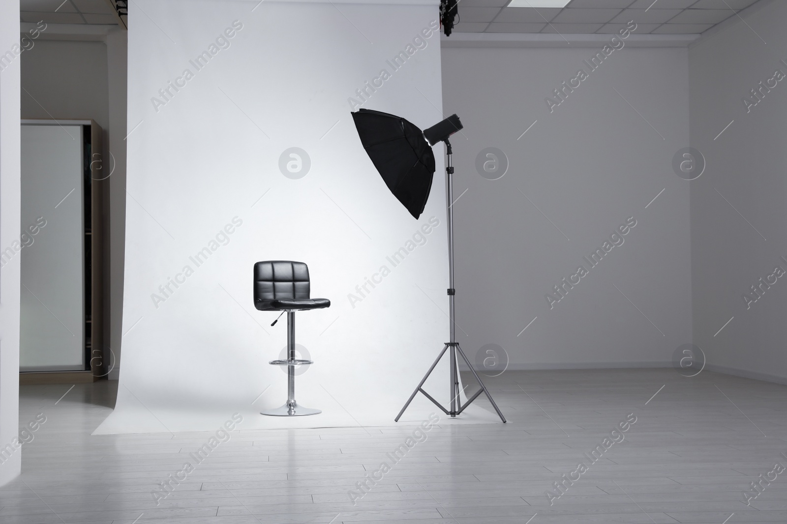 Photo of Photo studio interior with modern chair and professional lighting equipment