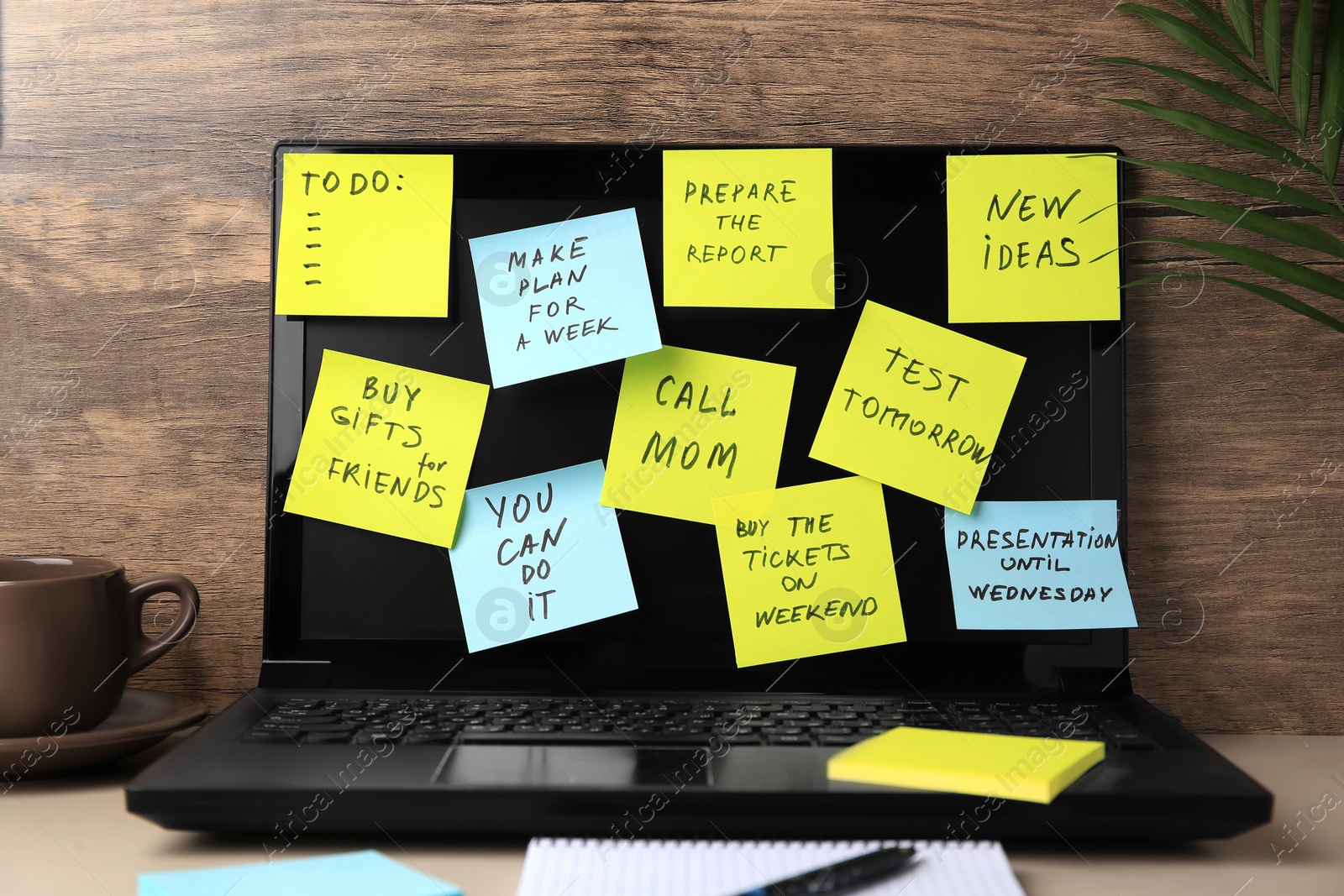 Photo of Laptop with reminder notes on beige desk indoors