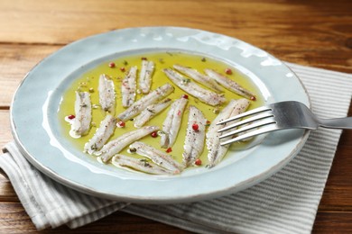 Tasty pickled anchovies with spices on table, closeup