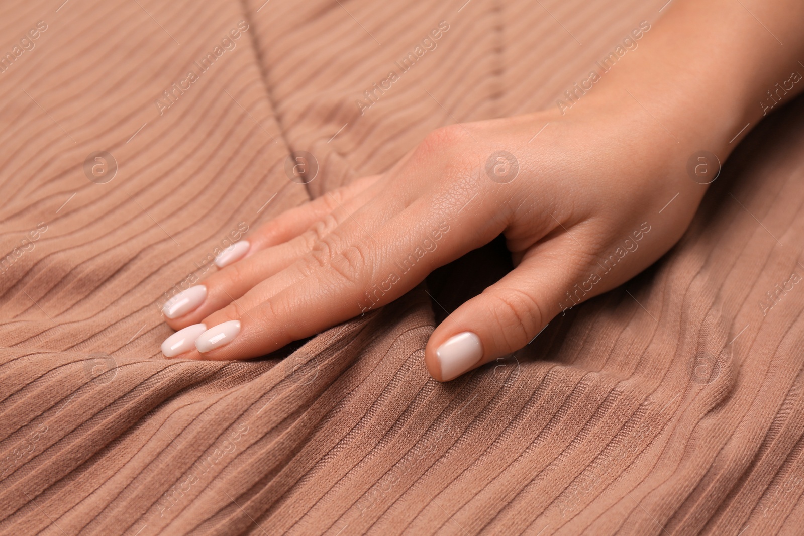 Photo of Woman touching soft brown fabric, closeup view