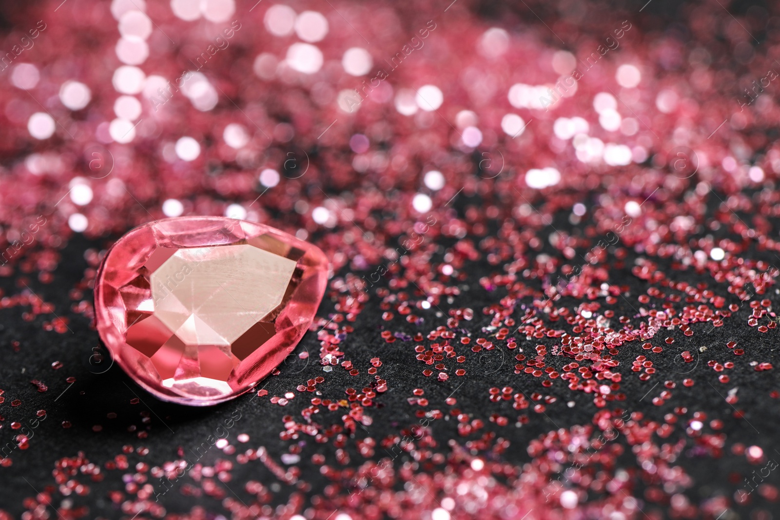 Photo of Beautiful gemstone and glitter on dark background, closeup. Space for text