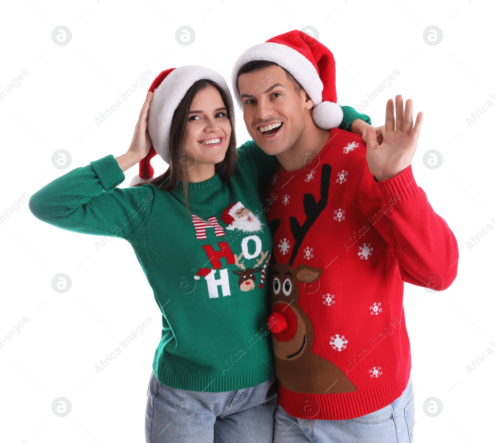 Photo of Beautiful happy couple in Santa hats and Christmas sweaters on white background