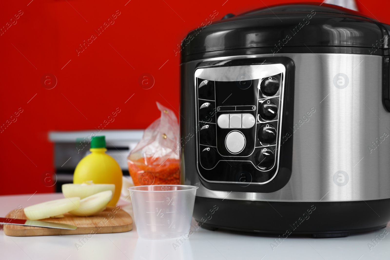 Photo of New modern multi cooker and products on table in kitchen