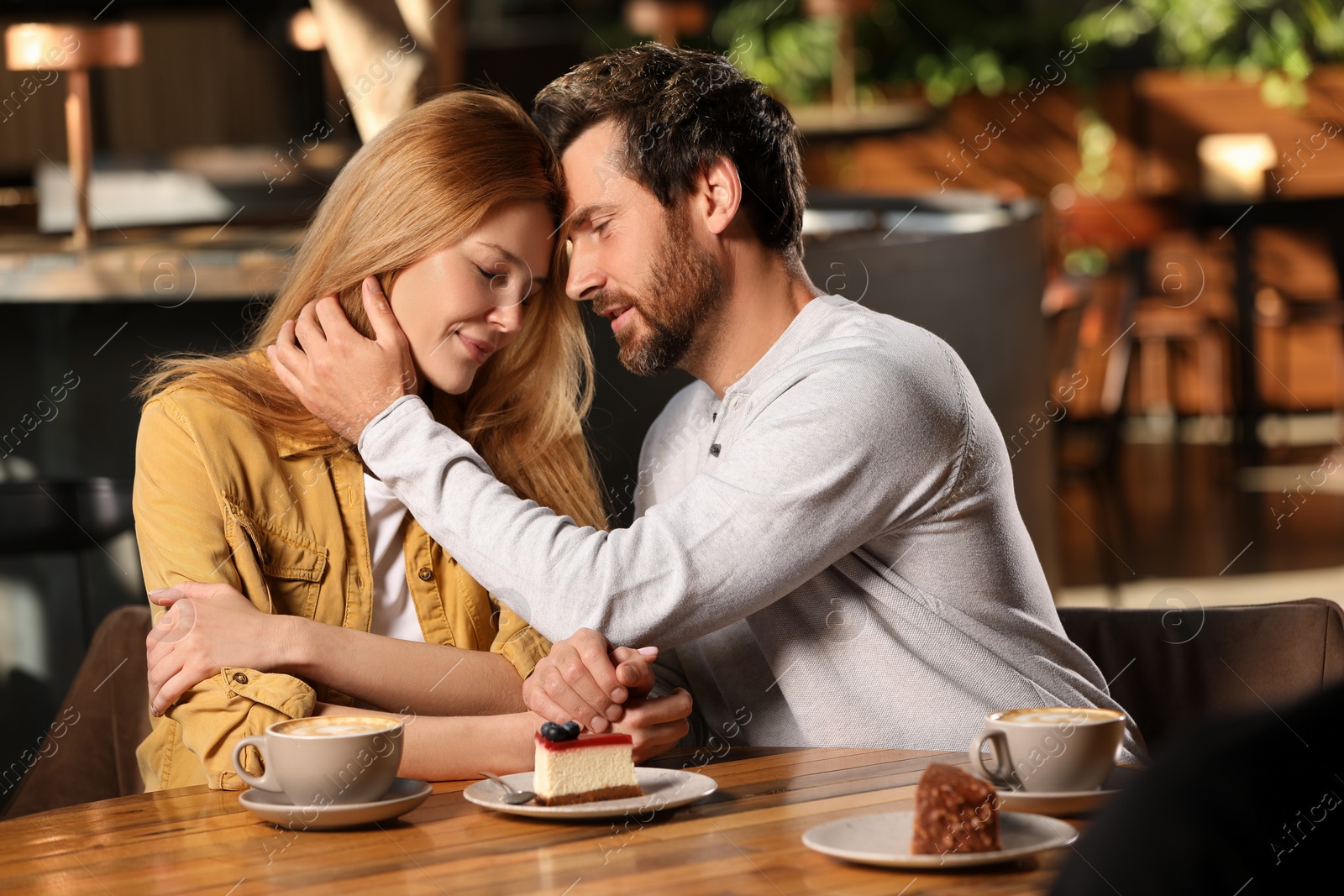 Photo of Romantic date. Lovely couple spending time together in cafe