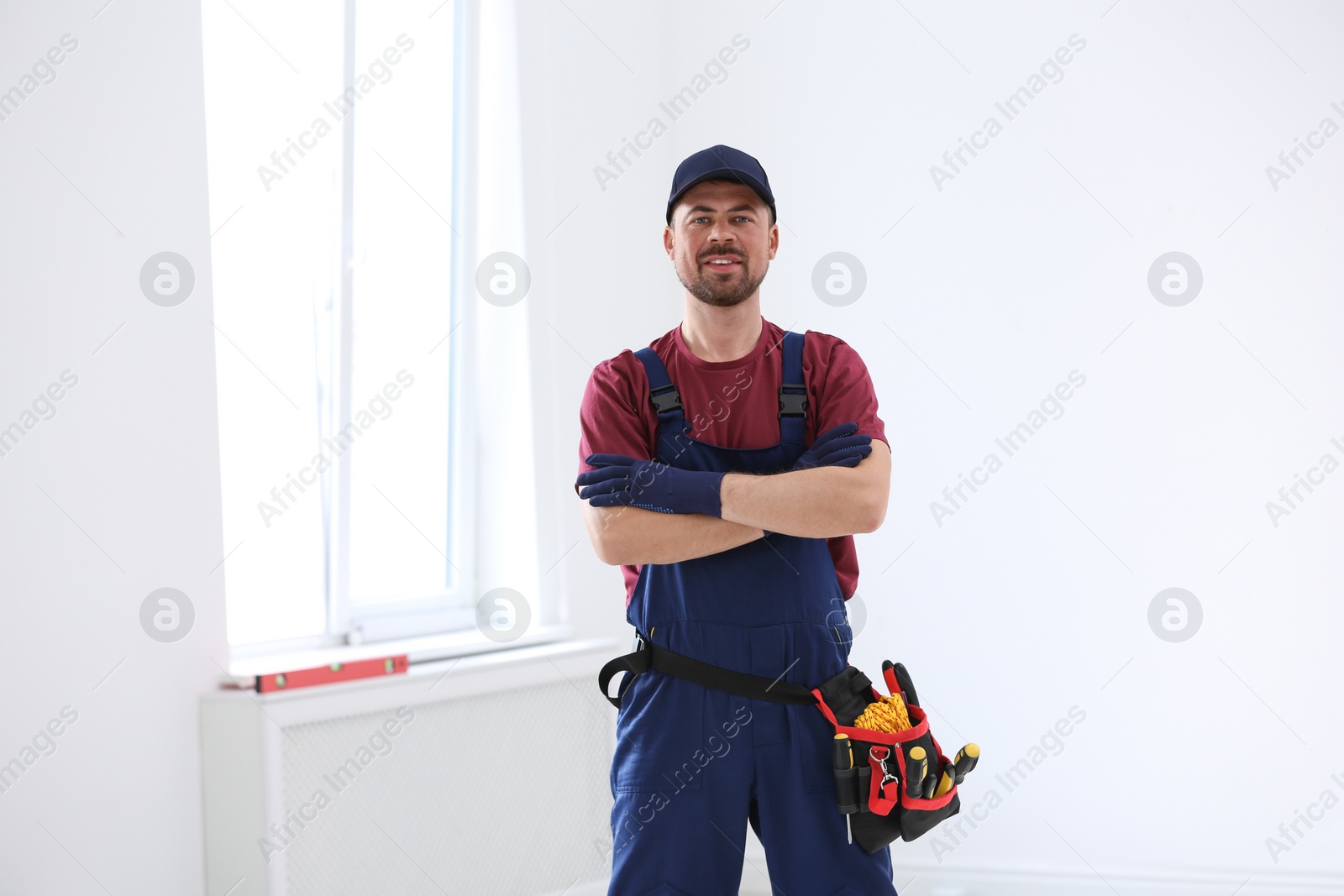 Photo of Portrait of professional construction worker with tool belt indoors