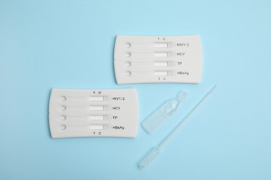 Photo of Disposable express test kit for hepatitis on light blue background, flat lay