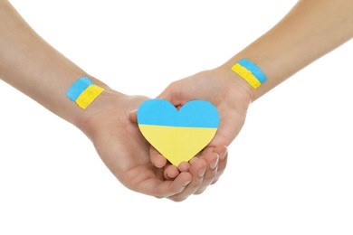 Man and woman holding paper heart in colors of Ukrainian flag on white background, closeup