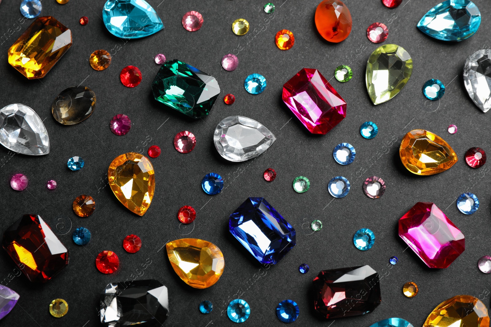 Photo of Different beautiful gemstones on black background, flat lay