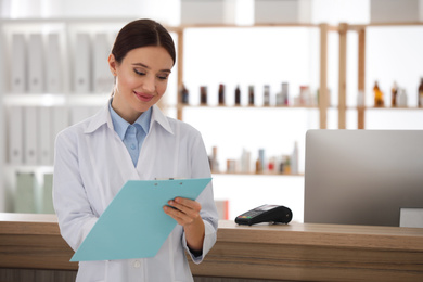 Photo of Professional pharmacist with clipboard in drugstore. Space for text