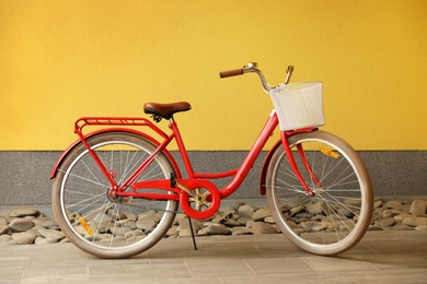 Photo of Modern color bicycle with basket near wall outside