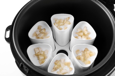 Photo of Cups of banana yogurt in multi cooker, closeup