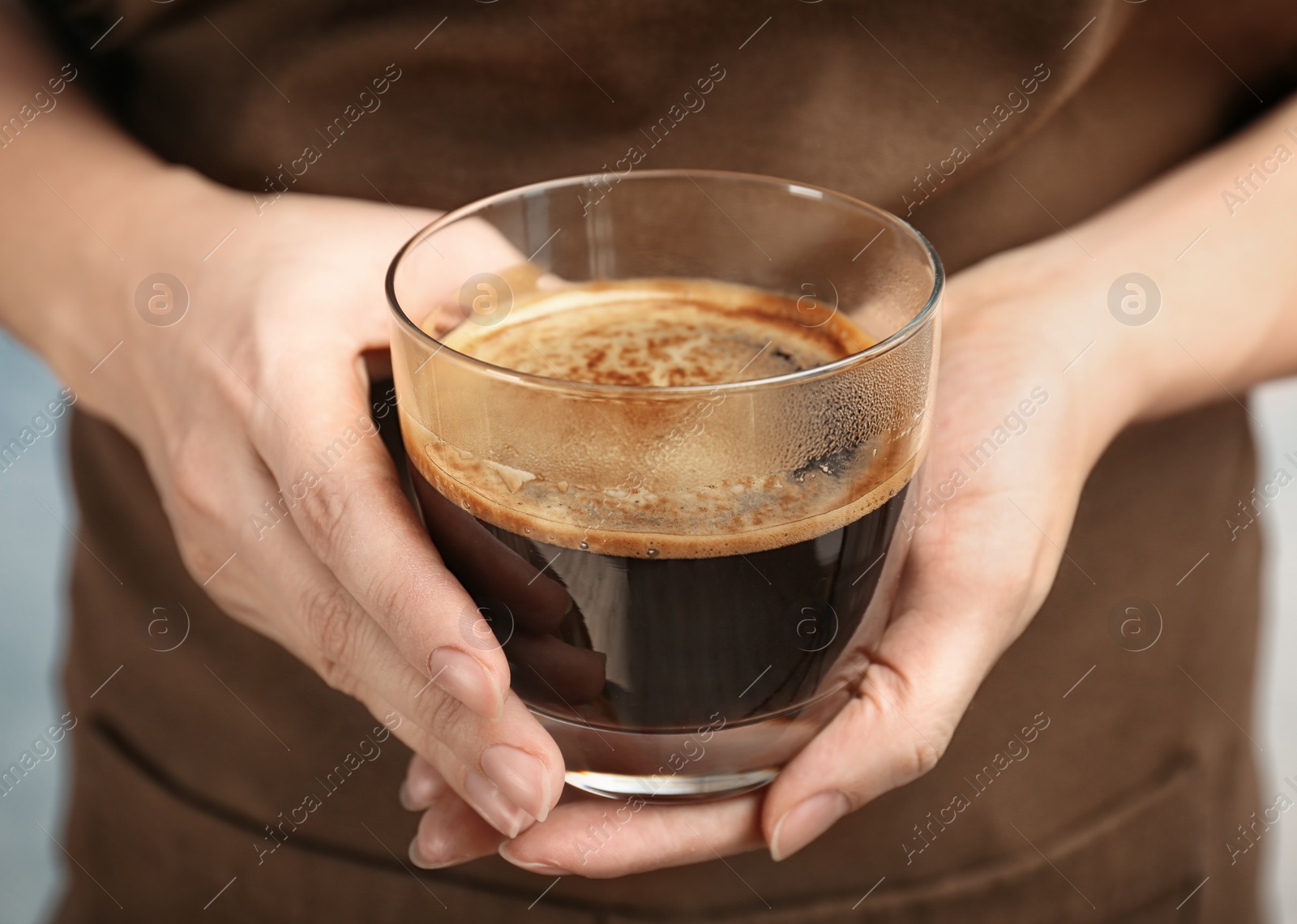 Photo of Woman holding glass of aromatic hot coffee, closeup