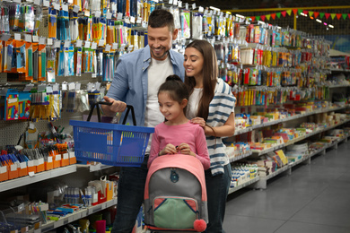 Photo of Family with little girl at section with school stationery in supermarket
