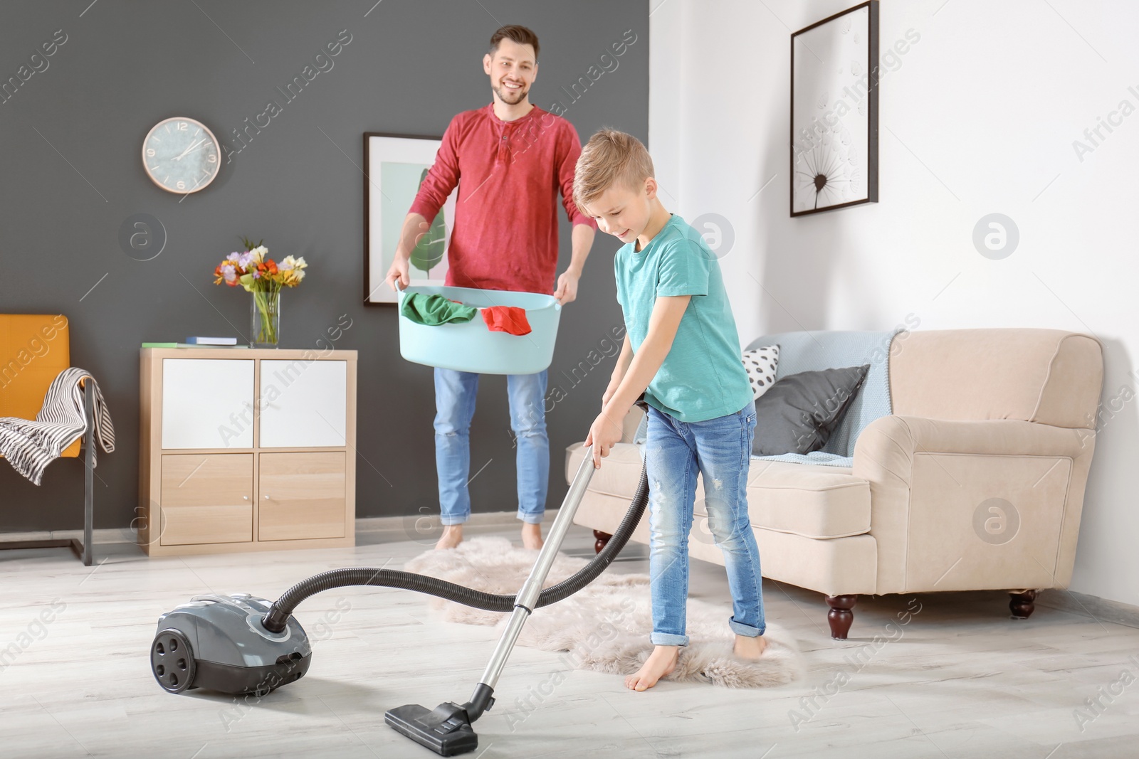 Photo of Little boy and his dad cleaning their house together