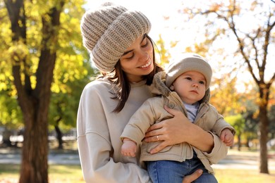 Happy mother with her baby son in park on autumn day