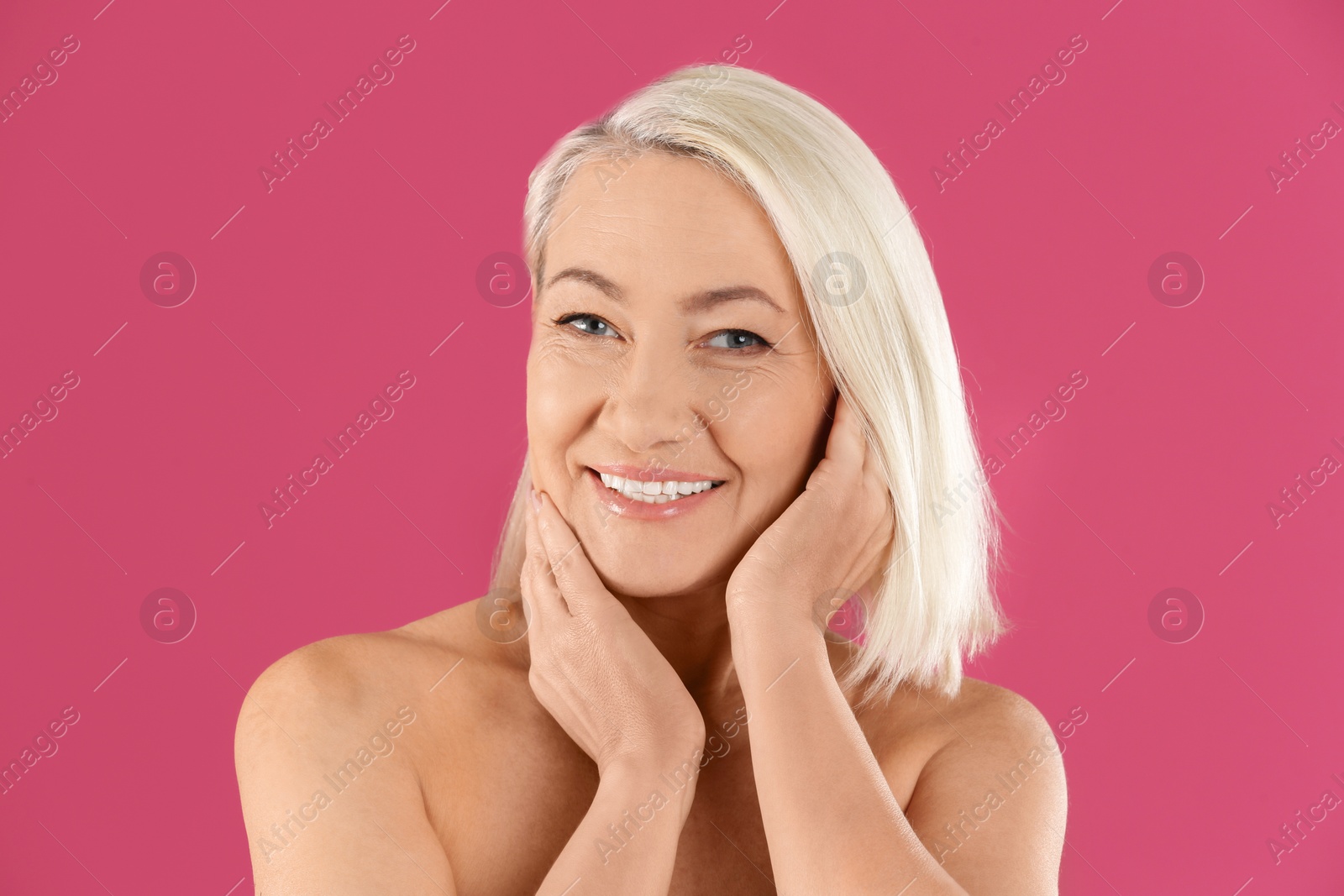 Photo of Portrait of beautiful mature woman on pink background