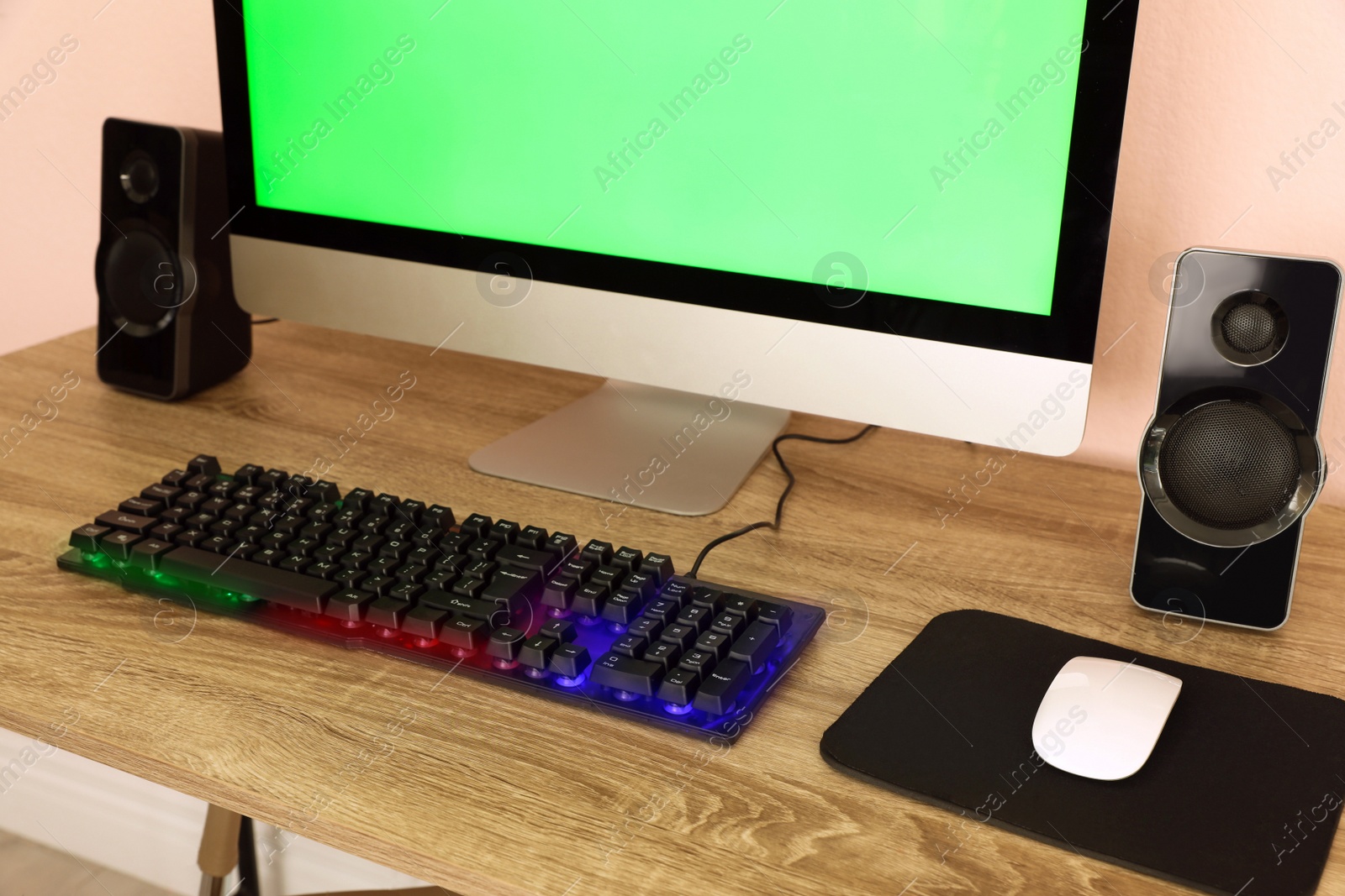 Photo of Modern computer and RGB keyboard on wooden table indoors