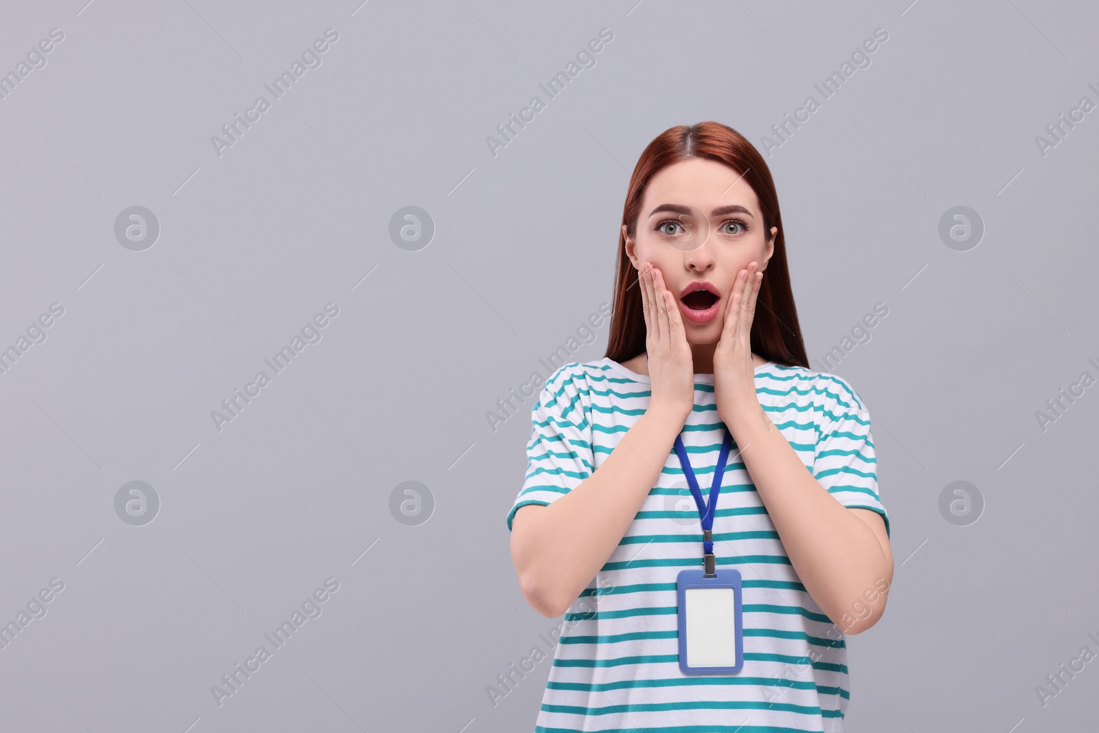 Photo of Shocked woman with vip pass badge on light grey background. Space for text