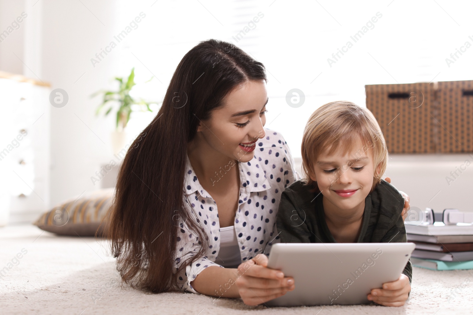 Photo of Mother and son reading E-book together at home