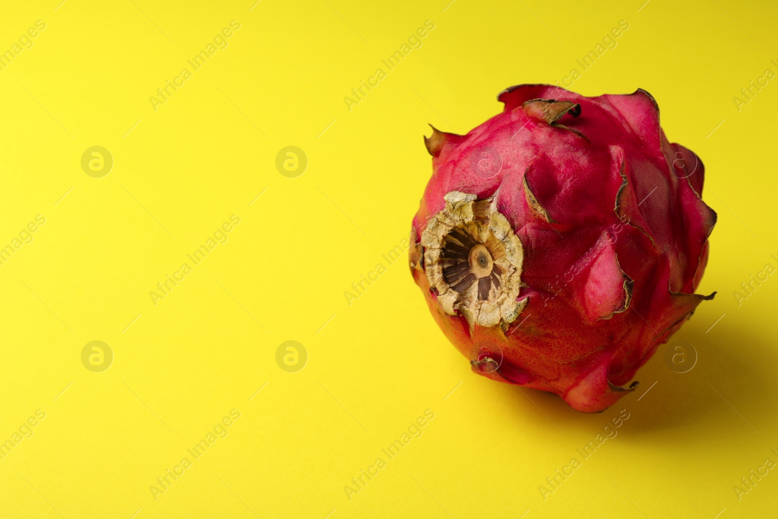 Photo of Delicious red pitahaya fruit on yellow background. Space for text