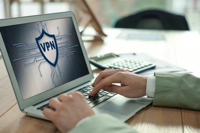 Image of Man using laptop with switched on VPN in office, closeup