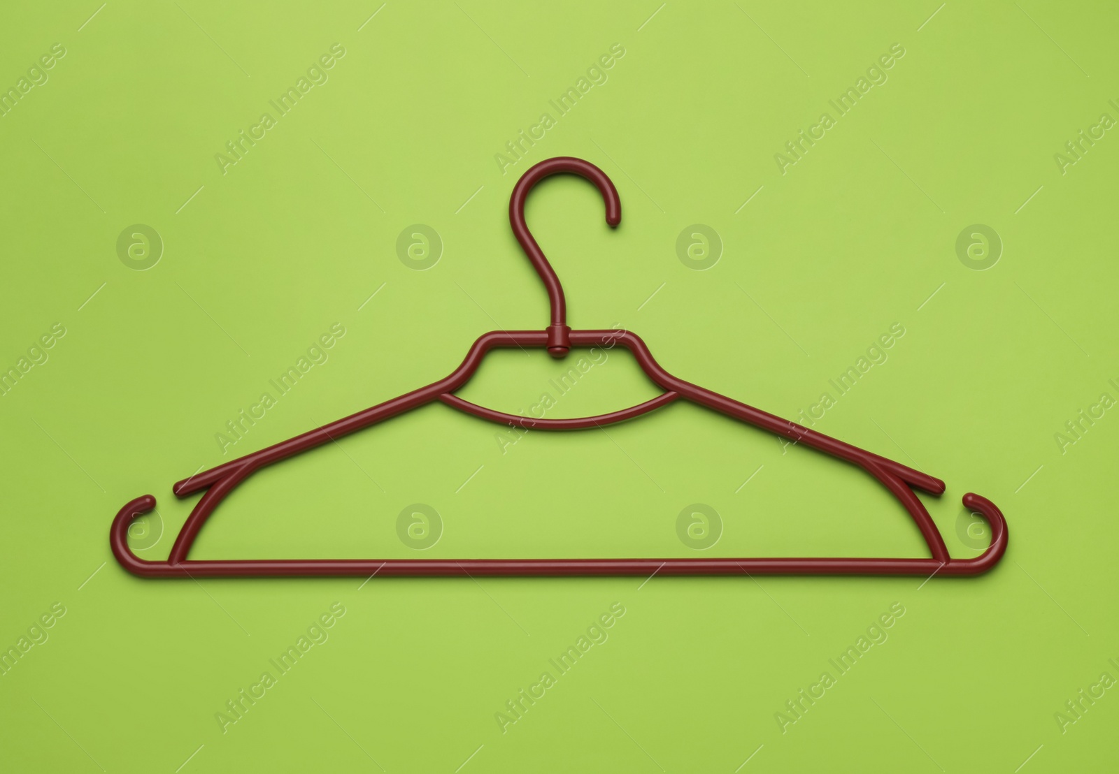 Photo of Empty clothes hanger on green background, top view